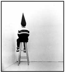 dunce in conical hat facing corner
