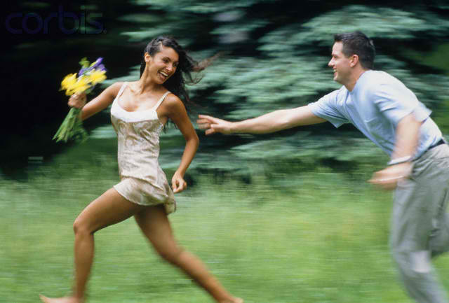 man chasing a woman with flowers